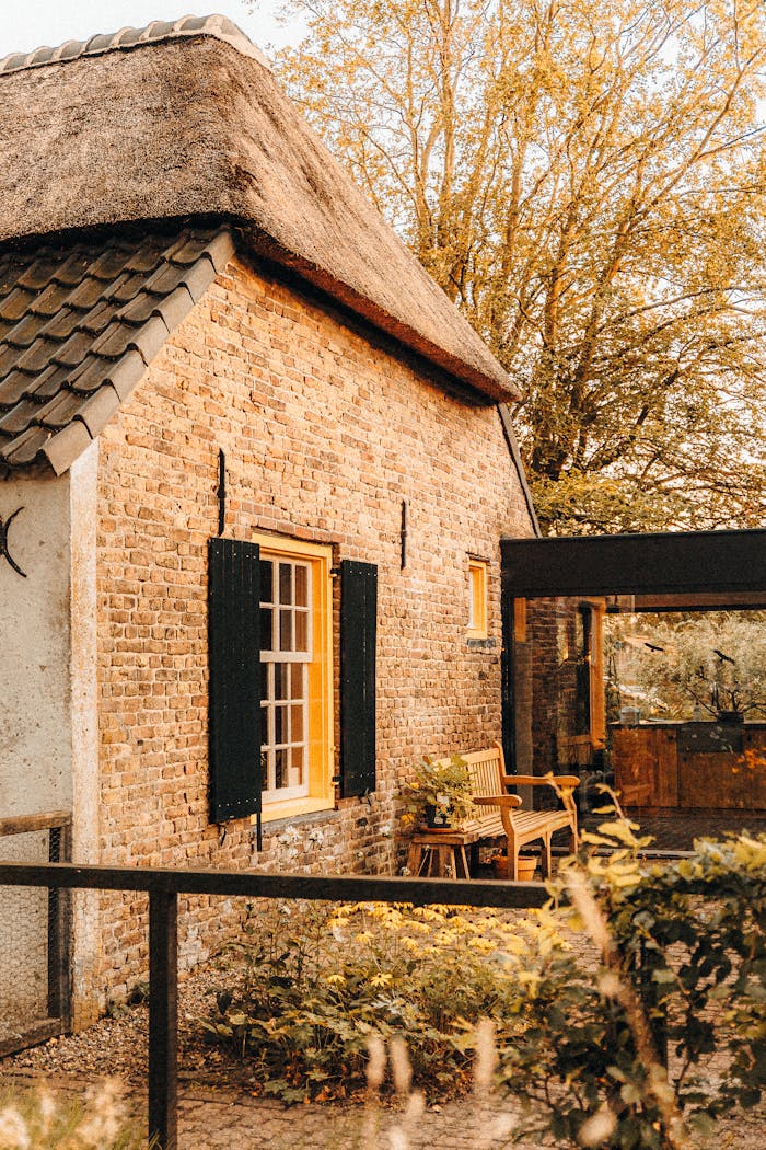 A picturesque Dutch cottage surrounded by a warm, vibrant garden, showcasing rustic architecture.